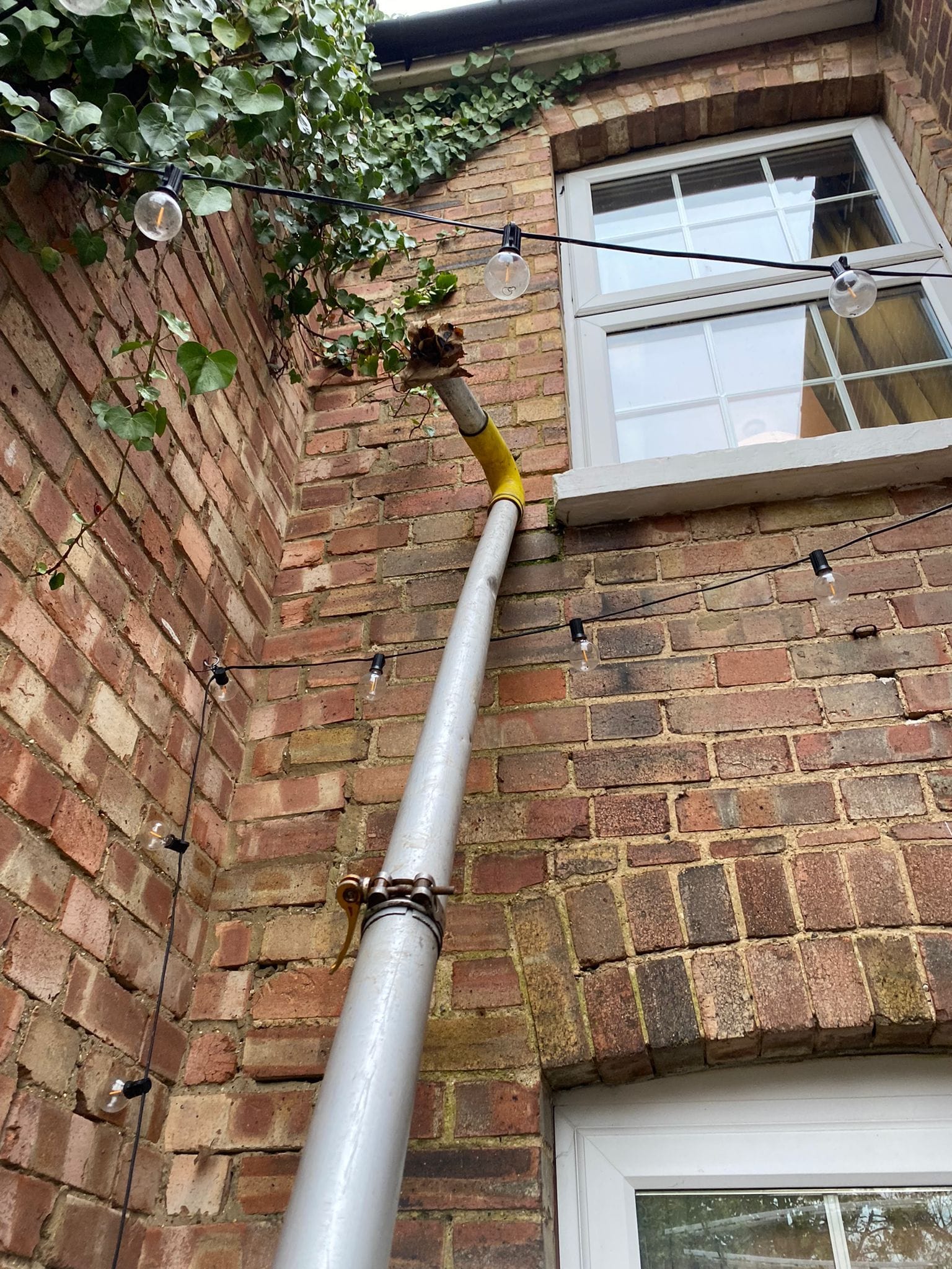 Gutter cleaning pole reaching debris out of pipes safely
